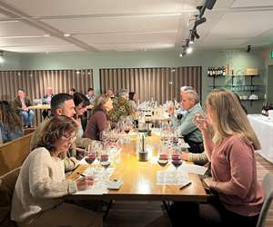Guests dining at a table while tasting 6 different wines and taking notes