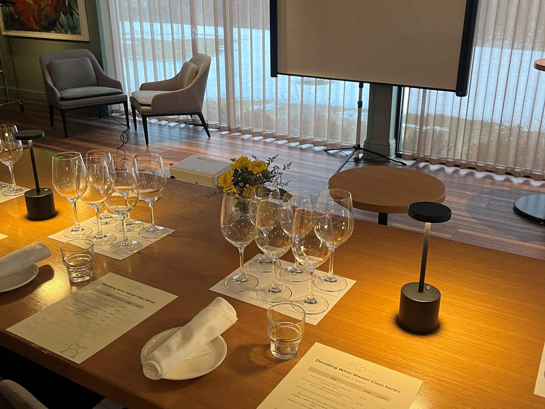 Empty wine glasses arranged on a table in front of a projector screen