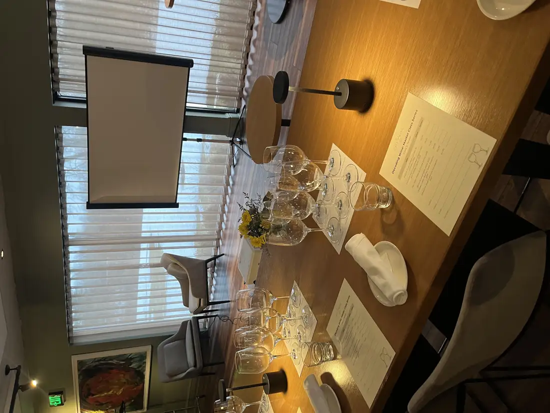 Empty wine glasses arranged on a table in front of a projector screen