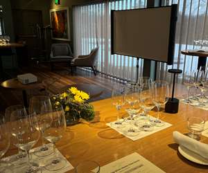 Empty wine glasses arranged on a table in front of a projector screen
