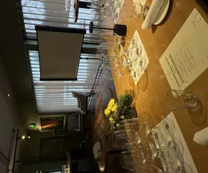 Empty wine glasses arranged on a table in front of a projector screen